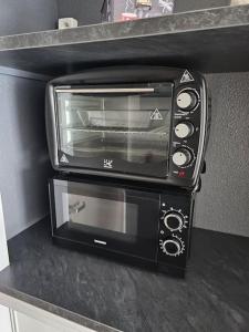 a toaster oven sitting on top of a counter at Appartement proche Futuroscope avec Parking in Jaunay-Clan