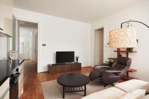 a living room with a couch and a tv at Stylish Designer Apartment at the Center of Vienna Naschmarkt in Vienna