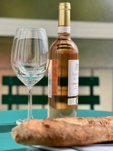 una botella de vino y una barra de pan junto a una copa en Risso - one bedroom with pool, newly renovated in spring 2024, en Niza