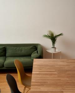 a living room with a green couch and a table at Designer Apartment in the City Center (Naschmarkt) in Vienna