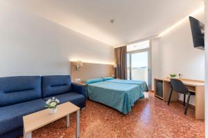 a hotel room with a bed and a blue couch at Port Europa in Calpe