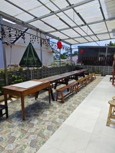Alex Home Đà Lạt في دالات: صف من طاولات النزهة الخشبية تحت سقف