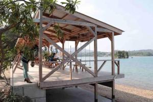 a wooden pavilion on a pier next to the water at 瑞海雲 in Nago
