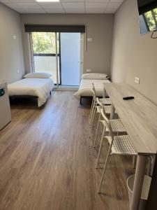 Pokój z 2 łóżkami, stołem i krzesłami w obiekcie Unicorn Residence for students New Opening 2024 w Walencji