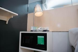 a kitchen with a microwave on a counter with a light at Go Hotels Iligan in Iligan City