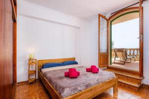 1 dormitorio con 1 cama con 2 almohadas rojas en Apartamento Voramar Mhm Cala Bona, en Cala Bona