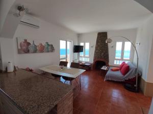 Casa Mar في أغيلاس: غرفة معيشة مع طاولة وغرفة معيشة مع موقد