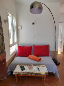 Habitación con cama con almohadas rojas y mesa. en Casa Mar en Águilas