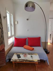 Cette chambre comprend un lit avec des oreillers rouges et une table. dans l'établissement Casa Mar, à Águilas