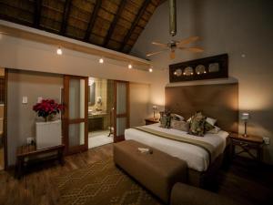 ein Schlafzimmer mit großem Bett und Couch in der Unterkunft Fairview Hotels,Spa & Golf Resort in Tzaneen