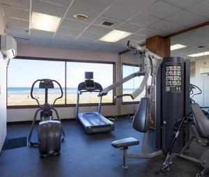 a gym with cardio equipment and a view of the beach at Promenade Inn & Suites Oceanfront in Seaside