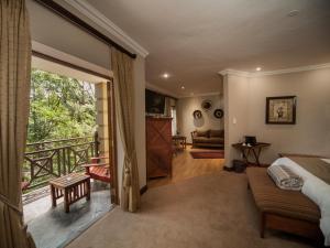 ein Schlafzimmer mit einem Bett und einem Balkon in der Unterkunft Fairview Hotels,Spa & Golf Resort in Tzaneen + 37 Fotos