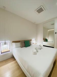 a white bedroom with a large bed and a mirror at ATSEDEN apartment - Opción a parking - in San Sebastián