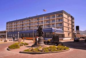 a large building with a statue in front of it at Promenade Inn & Suites Oceanfront in Seaside