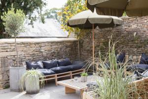 un patio con sofás, una mesa y una sombrilla en BULL Burford en Burford
