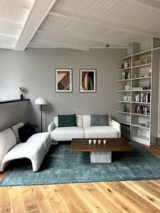 uma sala de estar com um sofá e uma mesa de centro em Charmante maison dans un coin de verdure à Boitsfort em Bruxelas