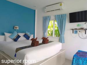 2 letti in una camera con blu e bianco di Phannarai House a Lamai Beach
