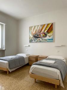duas camas num quarto com um quadro na parede em Palazzo Antoniazzi em Verona