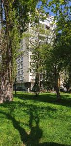 um edifício num parque com árvores em frente em 2 Bedroom Apartment, Grbavicka em Sarajevo