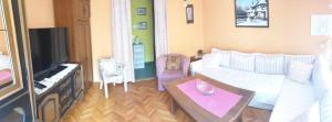 uma sala de estar com um sofá branco e uma mesa em 2 Bedroom Apartment, Grbavicka em Sarajevo