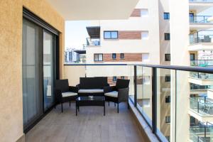 Un balcón con sillas y una mesa en un edificio. en Luxury Suite Apartment #58 By Hashdera Eilat, en Eilat