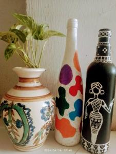 drei Vasen auf einem Tisch mit einer Pflanze in der Unterkunft Traveler House in Dimapur