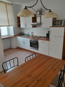 a kitchen with white cabinets and a wooden table at B10-LINDE in Baden-Baden
