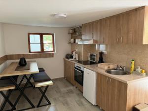 a kitchen with wooden cabinets and a sink at Vikendica Ozren in Soko Banja