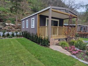 a tiny house with a deck in a yard at Chalet Hockslee in Goebelsmuhle
