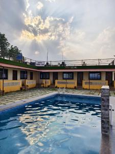 een gebouw met een zwembad ervoor bij Shayadri Farmhouse in Mahabaleshwar