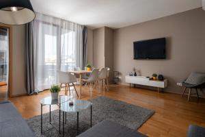 sala de estar con mesa y TV en Central Passage Apartments by Vagabond, en Budapest