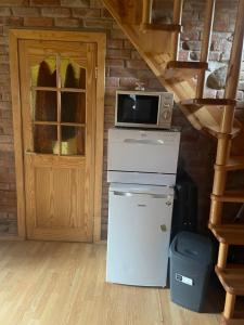 a microwave on top of a refrigerator next to a door at Sveikatinimas kaime in Vilkaviškis