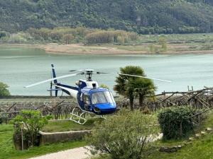 un hélicoptère bleu et blanc survolant un lac dans l'établissement Arzenhof, Baron Di Pauli, à Caldaro