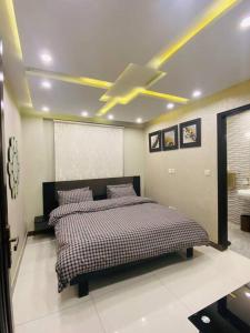 a bedroom with a bed and a ceiling fan at 102-Luxury Apartment to Admire your stay in Lahore in Lahore