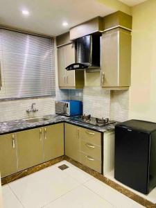 a kitchen with stainless steel cabinets and a black refrigerator at 102-Luxury Apartment to Admire your stay in Lahore in Lahore