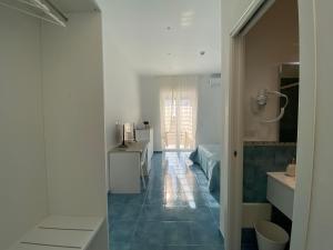een badkamer met een blauwe tegelvloer en een slaapkamer bij Casa Emy in Torre Annunziata