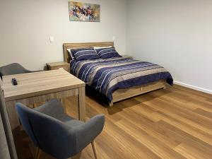ein Schlafzimmer mit einem Bett, einem Tisch und einem Stuhl in der Unterkunft The Morrison Motel in Swan View