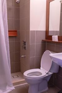 La salle de bains est pourvue de toilettes et d'un lavabo. dans l'établissement Tsai Hotel and Residences, à Cebu
