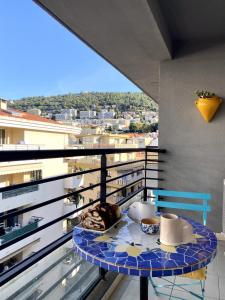 a table on a balcony with a view of a city at Appartement Duplex 4 personnes Quartier Riquier Nice in Nice
