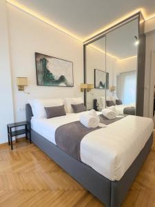 sypialnia z 2 łóżkami i dużym lustrem w obiekcie Acropolis Golden View Penthouse w Atenach