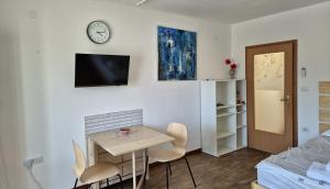 a room with a table and chairs and a clock on the wall at Nortra apartment in Tolmin