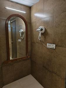 a bathroom with a mirror and a hair dryer at Hotel Heritage 2001, Nagpur in Nagpur