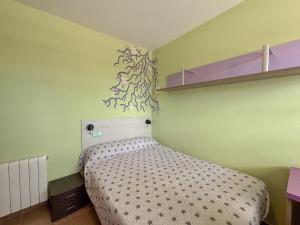 a small bedroom with a bed and a shelf at Clauhomes Golf and Sea in Tarragona