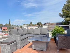 a patio with a couch and chairs and a table at Clauhomes Golf and Sea in Tarragona