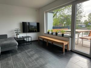 a living room with a couch and a table and a tv at Haus Seeblick in Allersberg