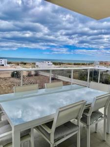 una mesa y sillas en un balcón con vistas al océano en Apartamento frente al mar, en Oliva
