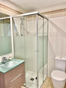 a bathroom with a shower and a toilet and a sink at Apartamento frente al mar in Oliva