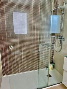 a shower with a glass door in a bathroom at Apartamento frente al mar in Oliva