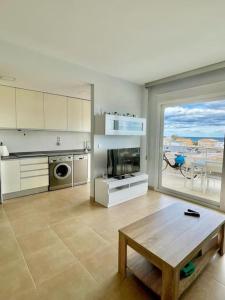 a living room with a table and a kitchen with a view at Apartamento frente al mar in Oliva