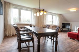 een eetkamer met een houten tafel en stoelen bij Ferienwohnung "Tee Tied" 35225 in Hesel